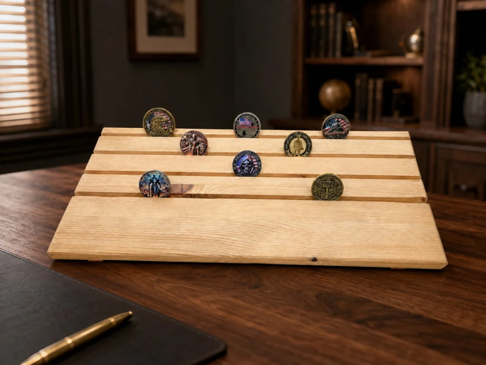 Wooden challenge coin holder with sample coins staged on a dark walnut desk in an office